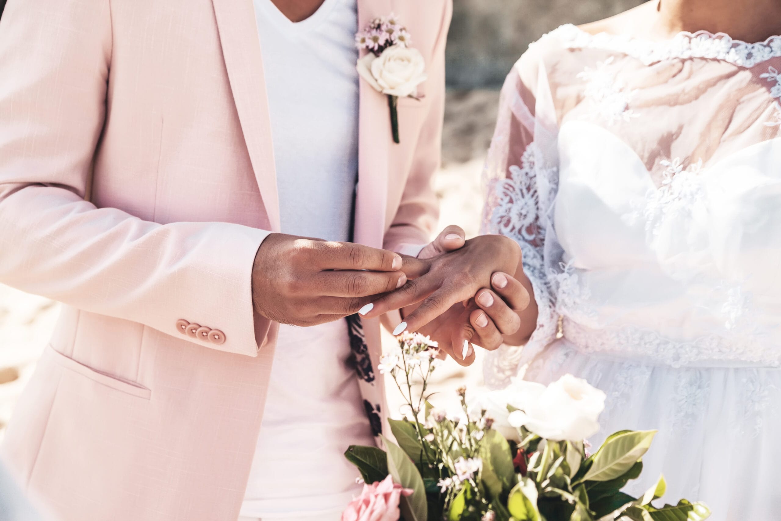 How Financial Secrecy is Destroying Modern Marriages 1 Groom in pink jacket wears ring on the finger of the bride on the beach